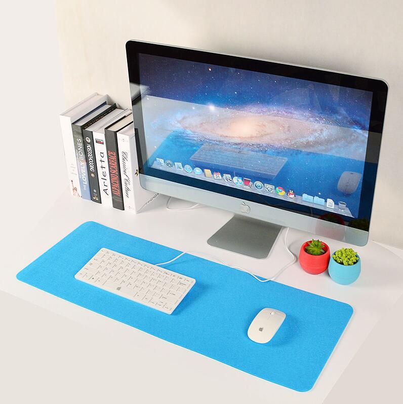 Blue desk mat with white keyboard and mouse on a modern computer workstation