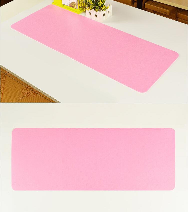 pink desk mat with white keyboard and mouse on a modern computer workstation